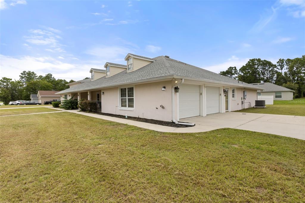 A single-story house with a light-colored exterior, a gray shingled roof, and an attached garage — 639 MARION OAKS TRAIL, OCALA, FL