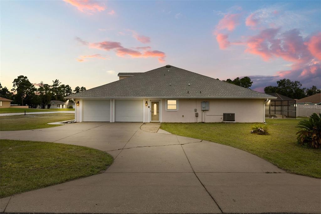 A side view of a single-story duplex with two garage doors and three roof dormers — 639 MARION OAKS TRAIL, OCALA, FL