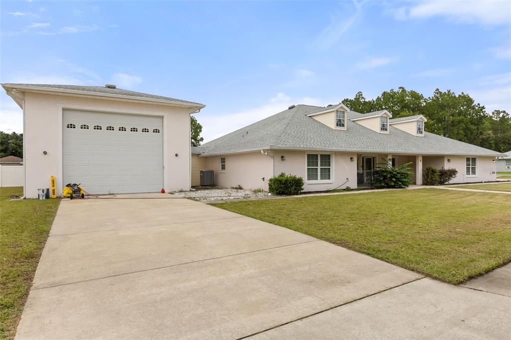 A single-story house with a two-car garage and a concrete driveway at sunset — 639 MARION OAKS TRAIL, OCALA, FL