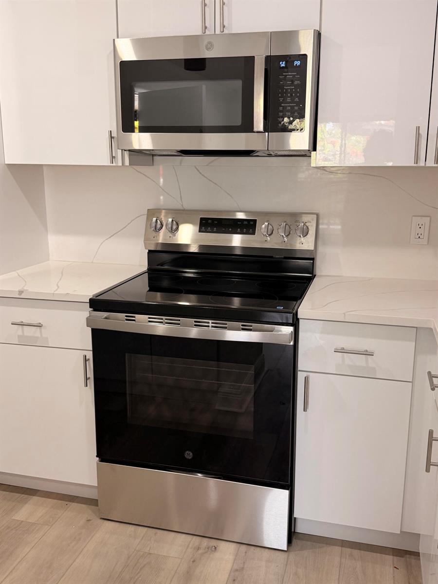 A kitchen features white cabinets, stainless steel appliances, and white countertops with grey veining — 10401 SW 108th Avenue # 240, Miami FL 33176, MIAMI, FL