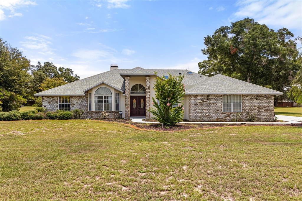 A single-story brick house with a gabled roof and a central arched entryway — 6231 ALBETH ROAD, ORLANDO, FL