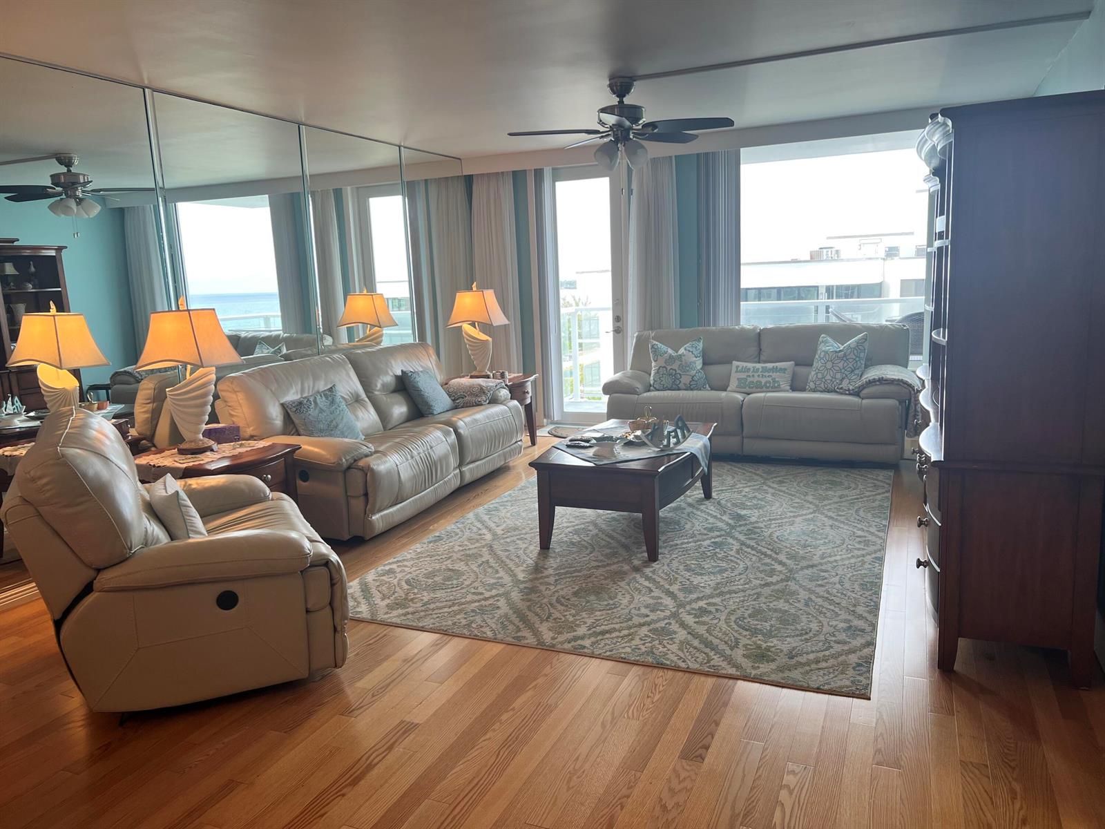 A living room features light leather furniture, a patterned area rug, and a mirrored wall — 3450 S Ocean Boulevard Boulevard # 701, Palm Beach FL 33480, PALM BEACH, FL