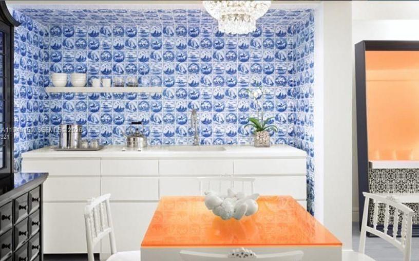 A kitchen area features blue and white patterned tile walls and an orange dining table — 1100 West Ave # 721, Miami Beach FL 33139, MIAMI BEACH, FL