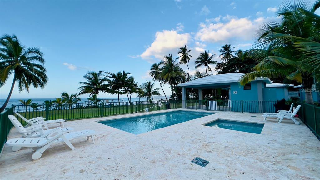 A swimming pool and hot tub sit on a stone patio overlooking the ocean — KM 2.6 CARR 441 VILLA 14, AGUADA, PR