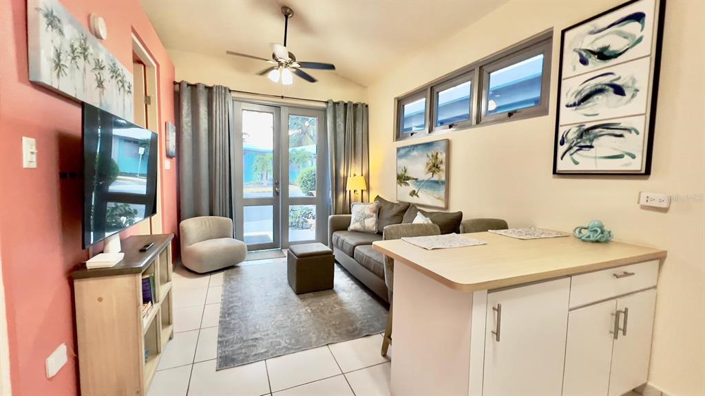 A living room features a sofa, a small armchair, a television, and a kitchen island — KM 2.6 CARR 441 VILLA 14, AGUADA, PR