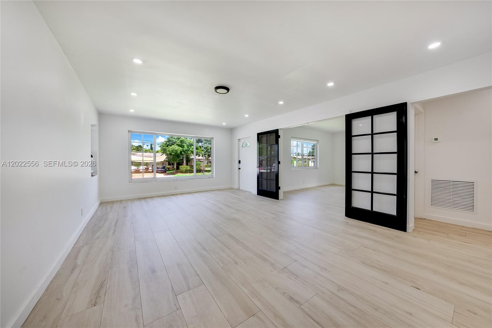 The exterior of a white house features a wooden deck with a pergola and stairs — 716 SW 5th Ave, Hallandale Beach FL 33009, HALLANDALE BEACH, FL
