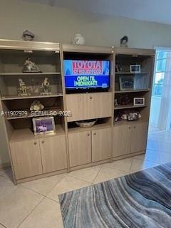 A light wood entertainment center with open shelving and cabinets stands against a wall — 1333 E Hallandale Beach Blvd # 406, Hallandale Beach FL 33009, HALLANDALE BEACH, FL