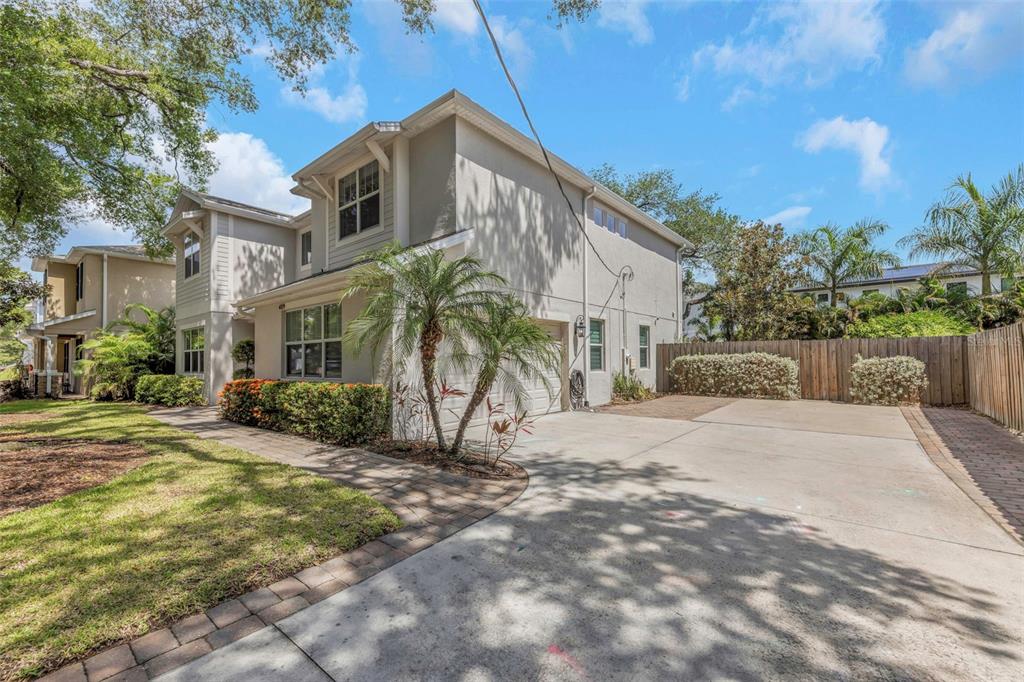 A two-story house with a concrete driveway, a palm tree, and a wooden fence — 4109 W VASCONIA STREET, TAMPA, FL