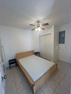 A bedroom with a wooden bed frame, tile flooring, a ceiling fan, and a closet — 7302 WOODHALL COURT, TAMPA, FL