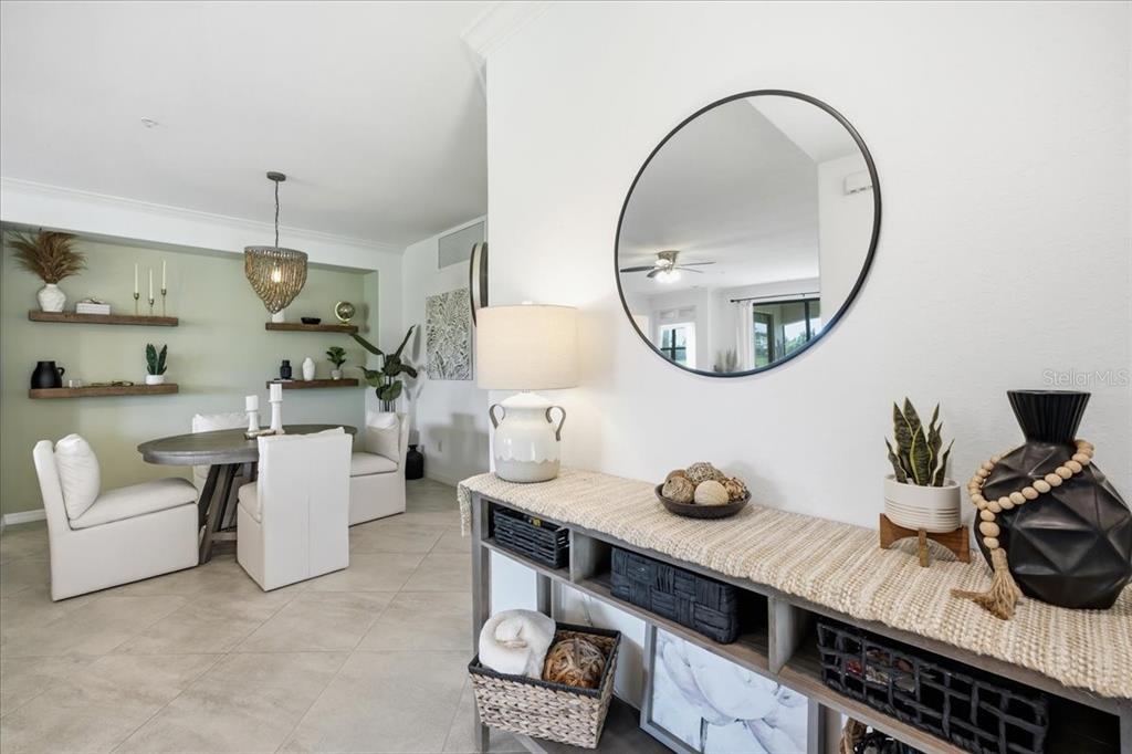 A dining area with floating shelves and a console table with a mirror in the foreground — 6055 WORSHAM LANE UNIT 101, BRADENTON, FL