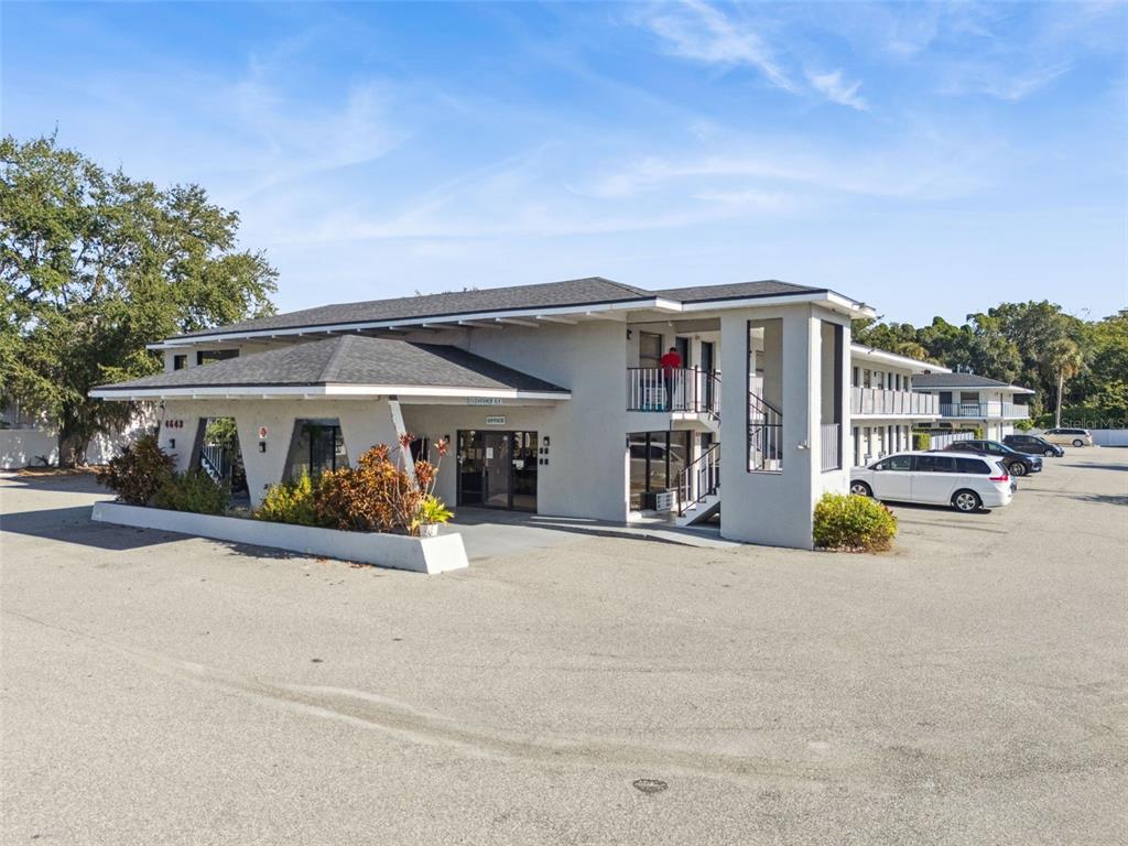 A two-story commercial building with a covered entrance, parking lot, and exterior staircases — 4643 W IRLO BRONSON MEMORIAL HIGHWAY, KISSIMMEE, FL