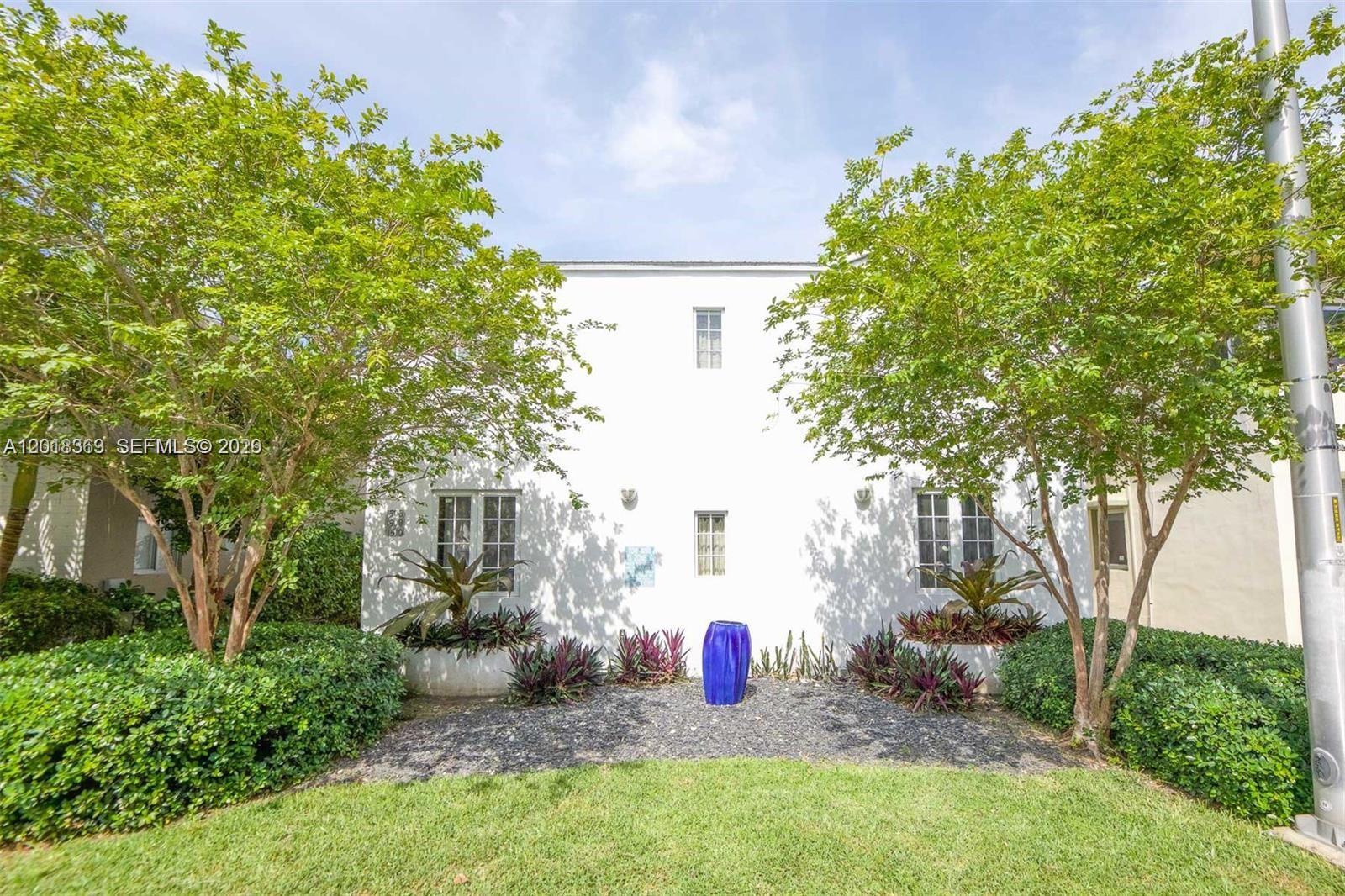 A white two-story building exterior features symmetrical windows, landscaping, and a blue decorative vase — 1508 Meridian Ave, Miami Beach FL 33139, MIAMI BEACH, FL