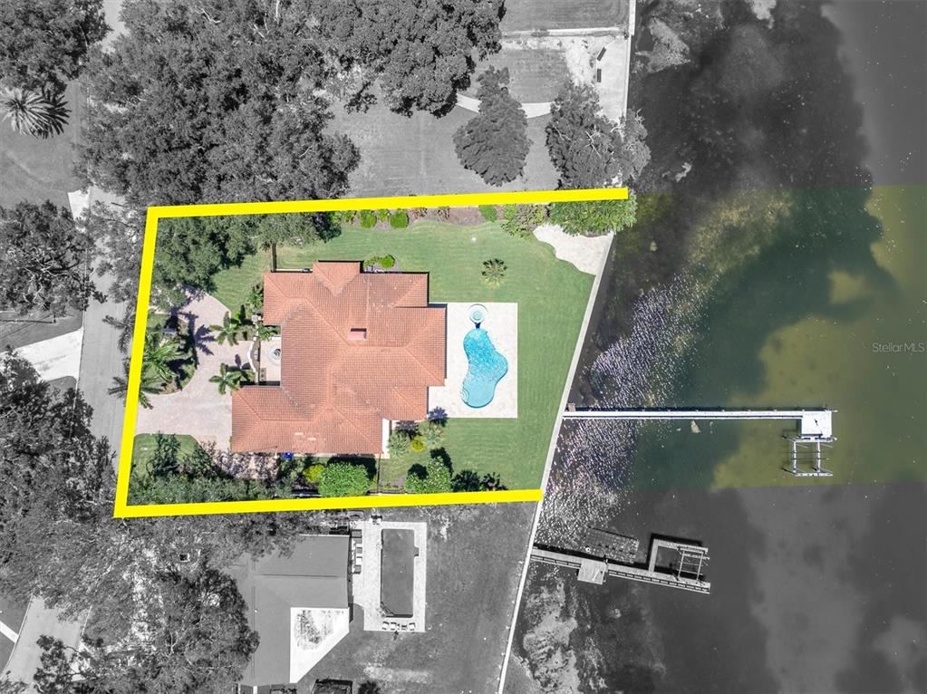 An aerial view shows a house with a red tile roof, pool, and private dock — 5810 BAHAMA SHORES DRIVE S, ST PETERSBURG, FL