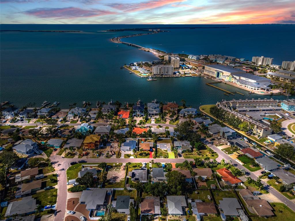 An aerial view shows a residential neighborhood situated along a bay near a bridge — 2476 CORONADO WAY, DUNEDIN, FL