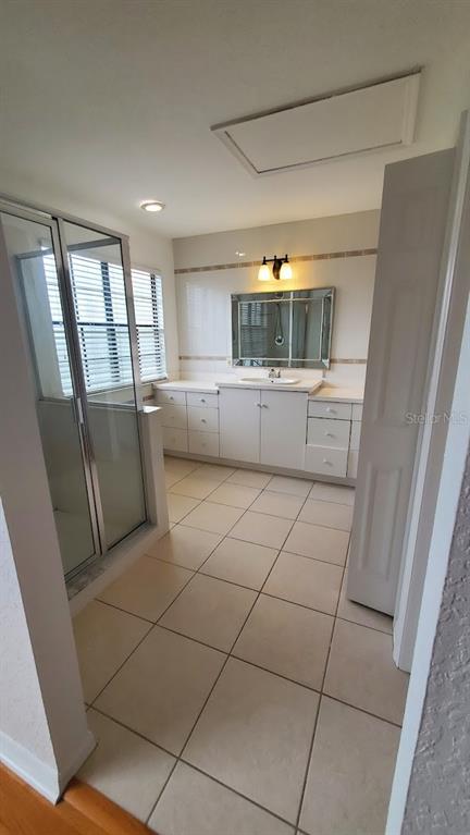 A bathroom features a glass-enclosed shower, a vanity with a mirror, and tiled flooring — 4176 BRENTWOOD PARK CIRCLE, TAMPA, FL