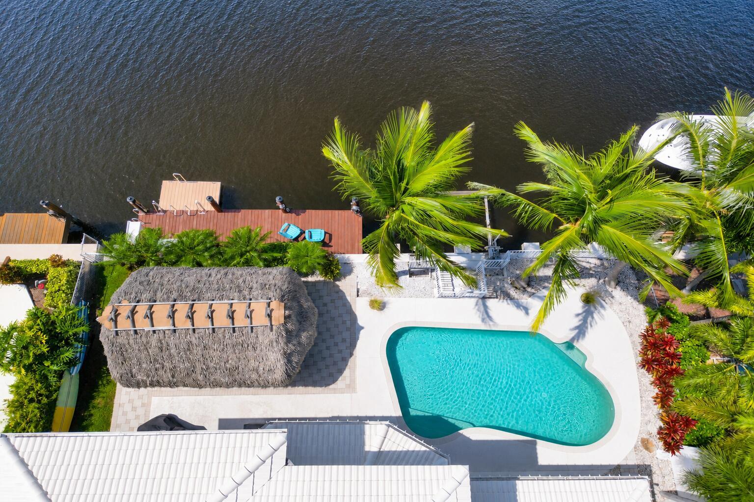 An aerial view of a waterfront backyard featuring a swimming pool, tiki hut, and dock — 240 SE 3rd Court, Pompano Beach FL 33060, POMPANO BEACH, FL
