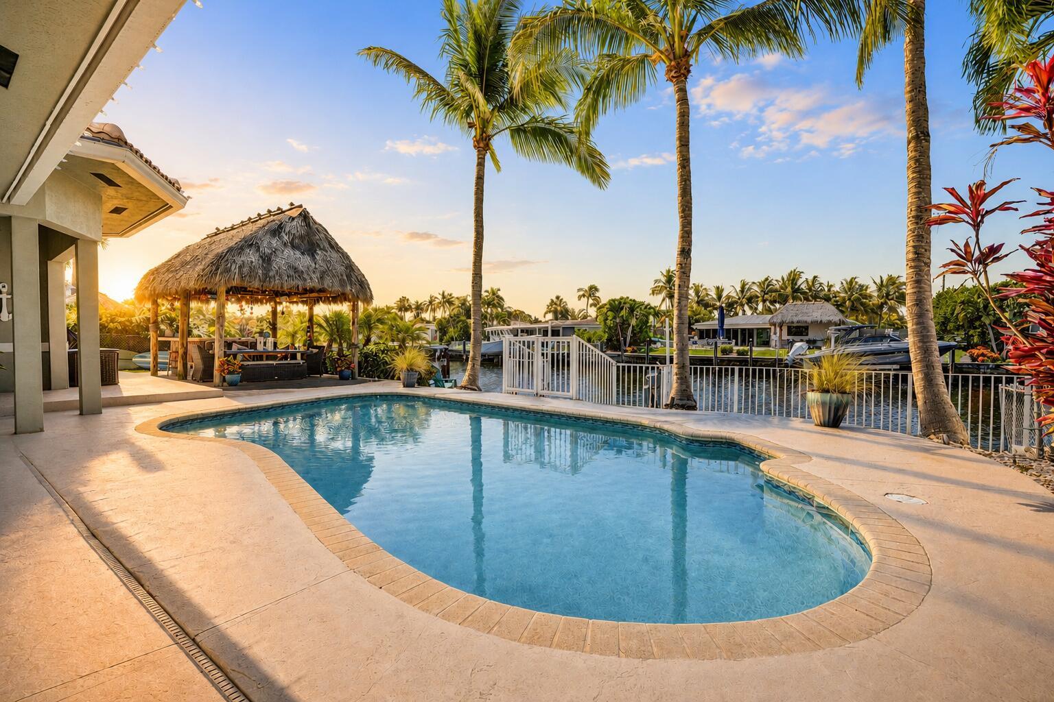 A swimming pool sits on a patio next to a tiki hut and palm trees — 240 SE 3rd Court, Pompano Beach FL 33060, POMPANO BEACH, FL
