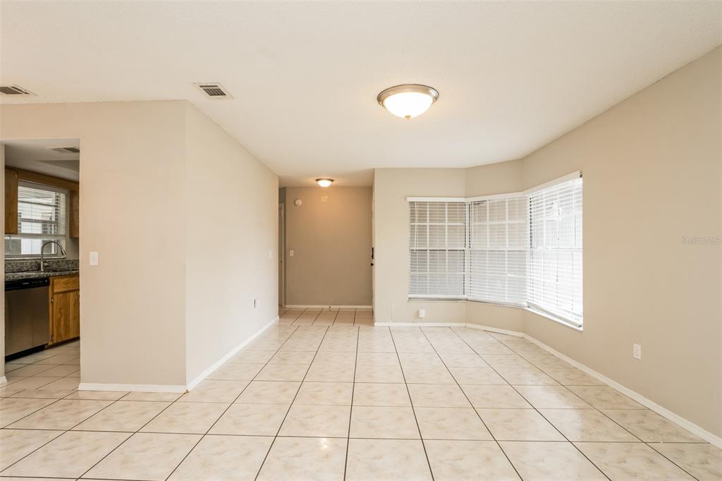 A dining area with beige tile floors, a bay window, and a ceiling light fixture — 2680 SWEET SPRINGS STREET, DELTONA, FL