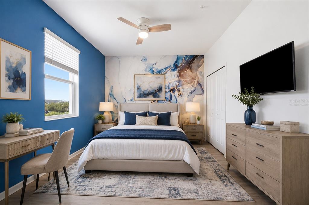 A bedroom features a blue accent wall, a mural behind the bed, and wood furniture — 8895 CABOT CLIFFS DRIVE UNIT 103, DAVENPORT, FL
