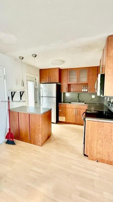 A kitchen features wood cabinets, stainless steel appliances, a center island, and light wood flooring — 1631 NE 114th St # 201, Miami FL 33181, MIAMI, FL