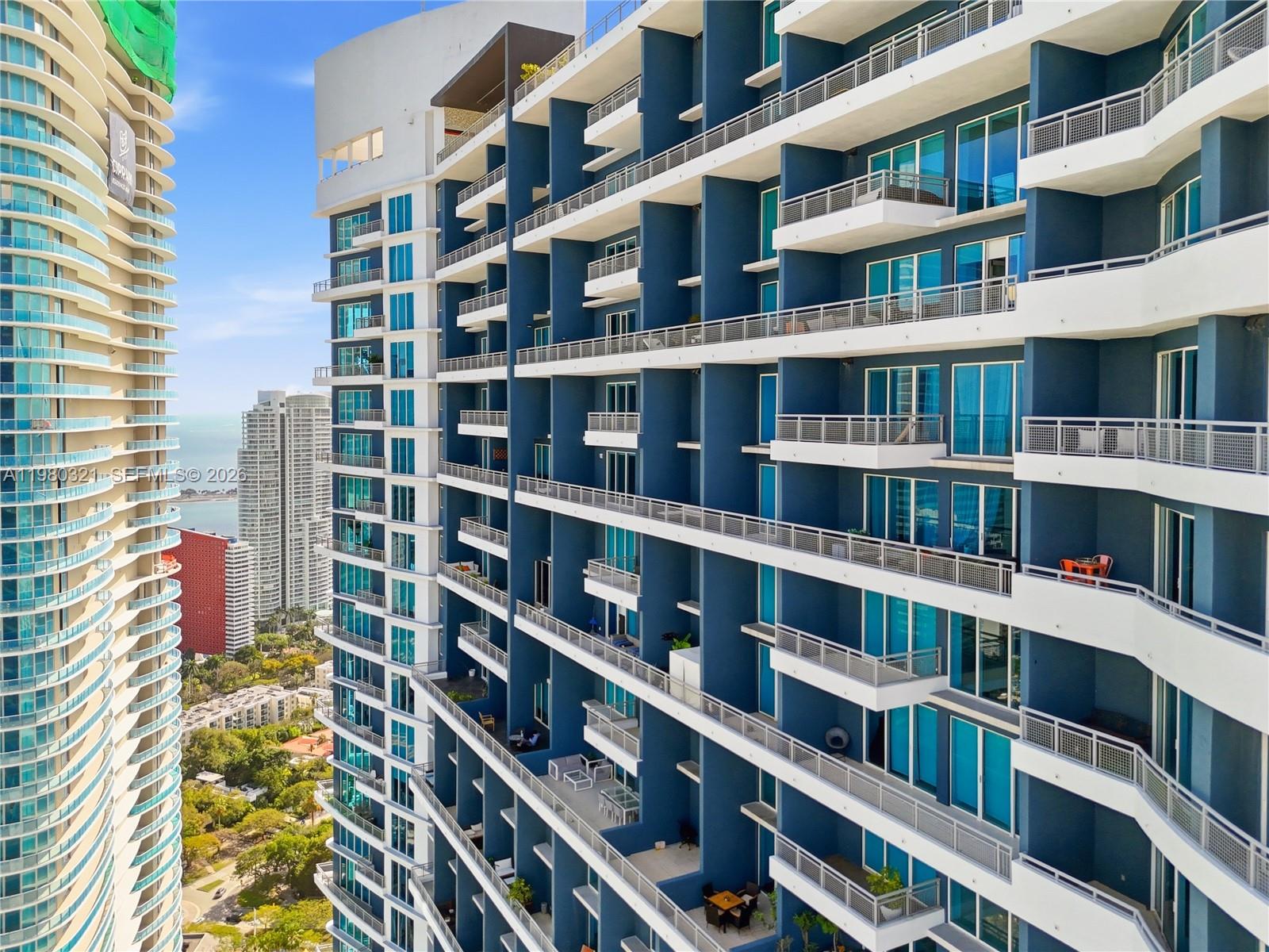 A high-angle view shows the exterior balconies of a modern blue high-rise apartment building — 60 SW 13th St # 4414, Miami FL 33130, MIAMI, FL