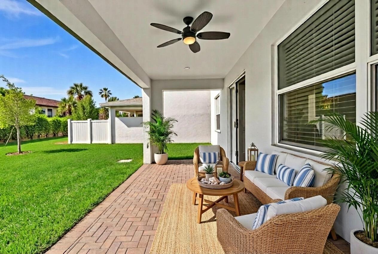 A covered patio features wicker furniture, a ceiling fan, and a view of a grassy yard — 7268 Lenora Lane, Lake Worth FL 33467, LAKE WORTH, FL