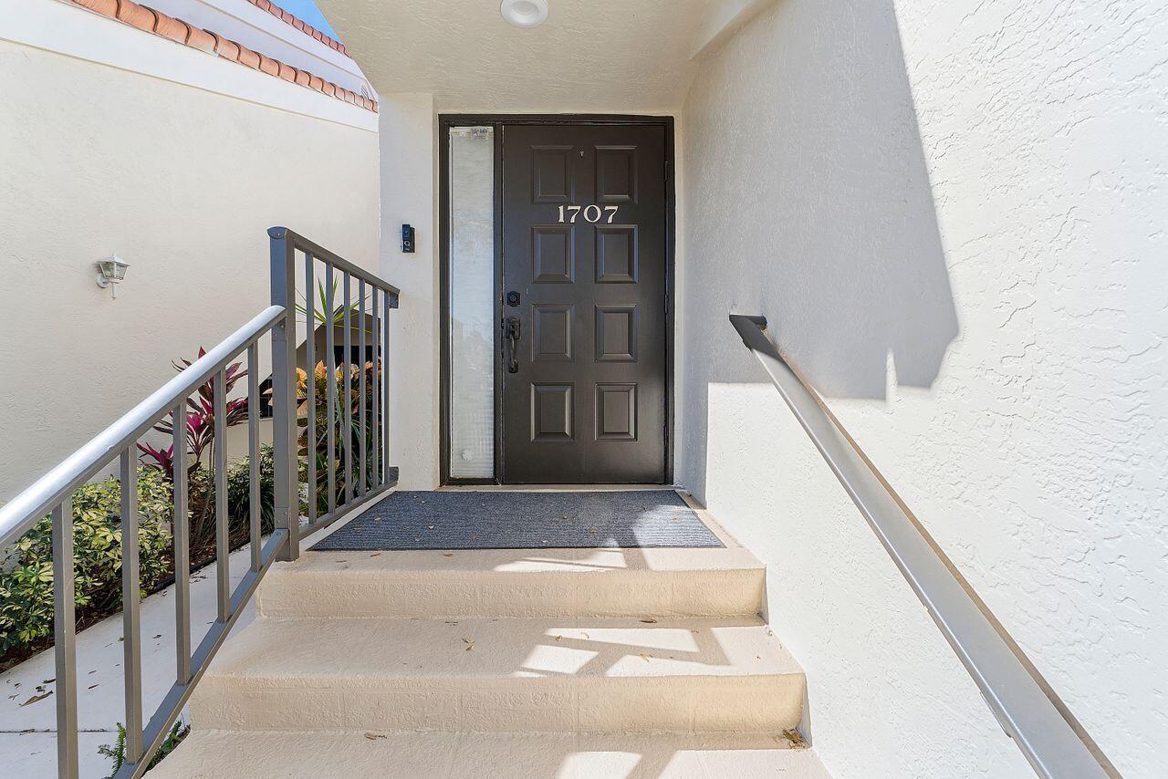 A dark front door with a side window is reached by concrete steps with railings — 17270 Boca Club Boulevard # 1707, Boca Raton FL 33487, BOCA RATON, FL