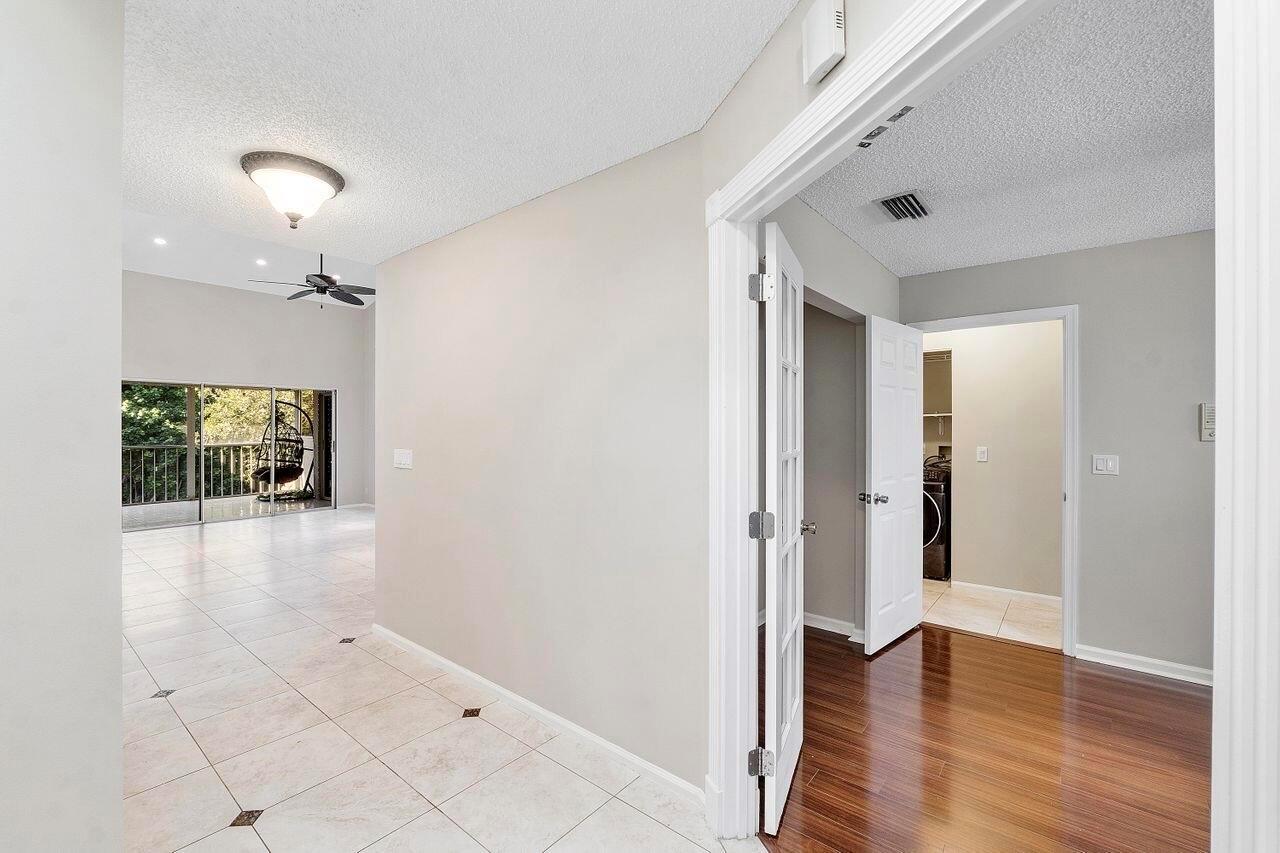 An interior view shows a tiled living area leading to a balcony and a room entrance — 17270 Boca Club Boulevard # 1707, Boca Raton FL 33487, BOCA RATON, FL