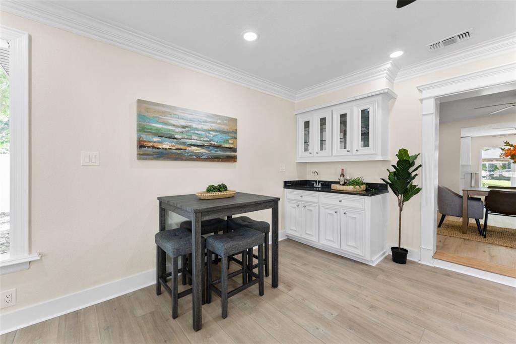A dining area features a dark wood table, four stools, and a white built-in bar — 1714 W SAINT ISABEL STREET, TAMPA, FL