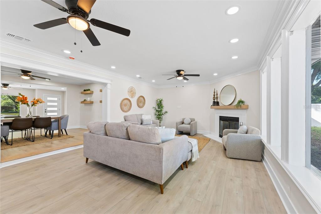 A bright living room features light wood flooring, a fireplace, and an adjacent dining area — 1714 W SAINT ISABEL STREET, TAMPA, FL