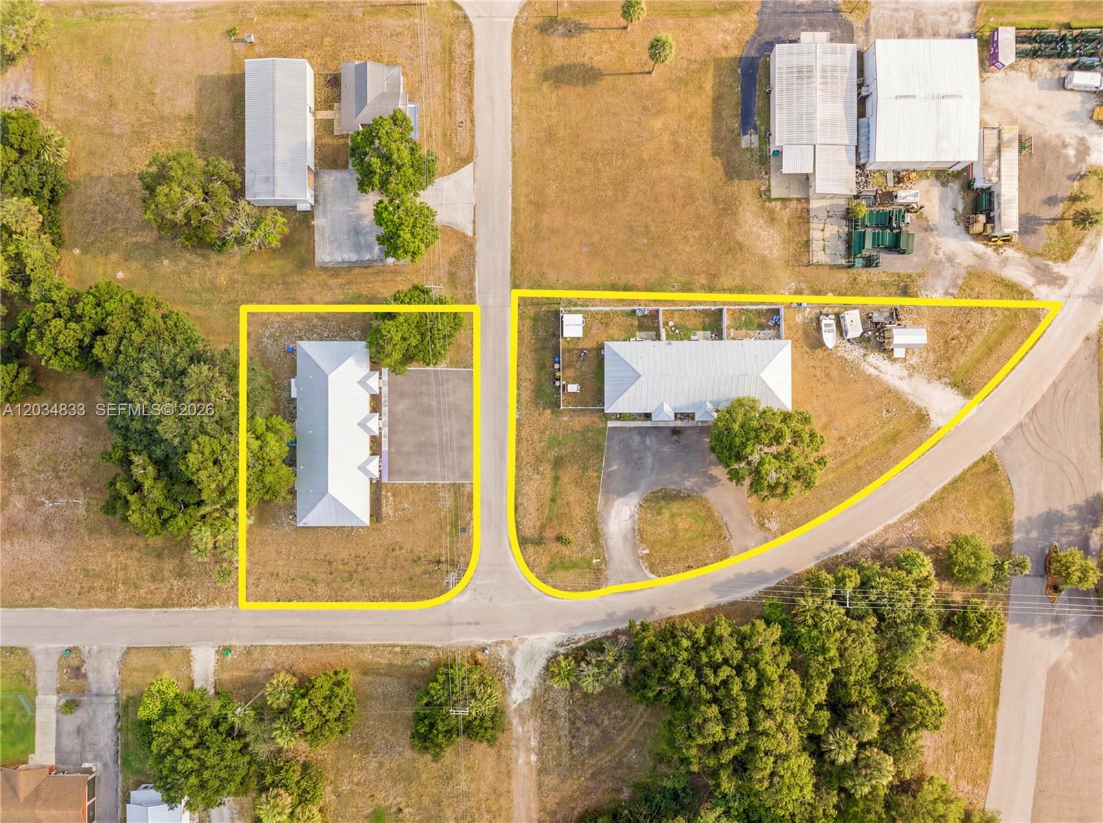 This aerial view shows two adjacent properties with buildings, driveways, and trees — 810 SW 2nd St, Okeechobee FL 34974, OKEECHOBEE, FL