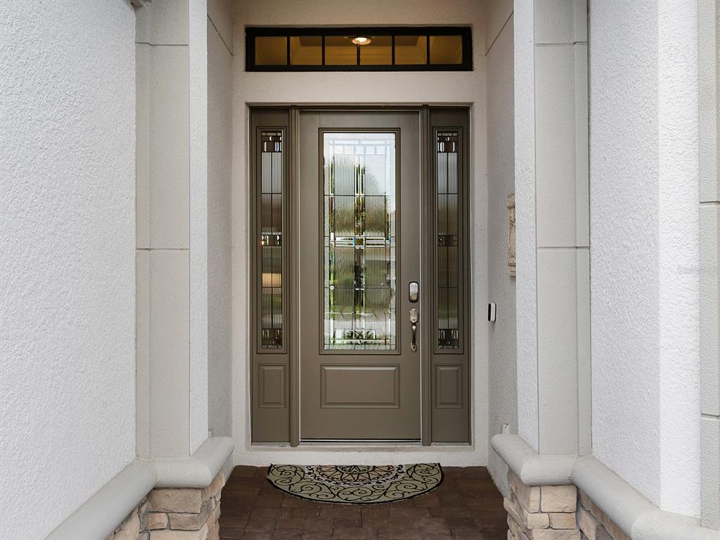 A front entryway features a brown door with glass panels, sidelights, and a transom window — 5365 SALCANO STREET, SARASOTA, FL
