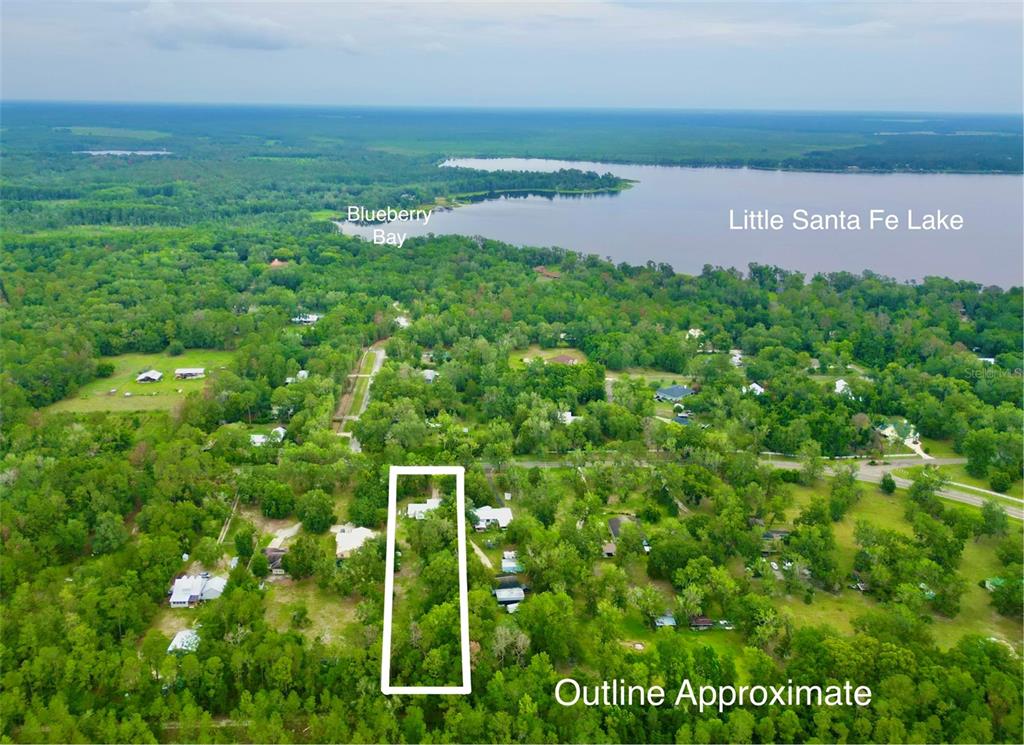 An aerial view shows a wooded residential lot outlined in white near Little Santa Fe Lake — 20517 NE 114TH AVENUE, WALDO, FL
