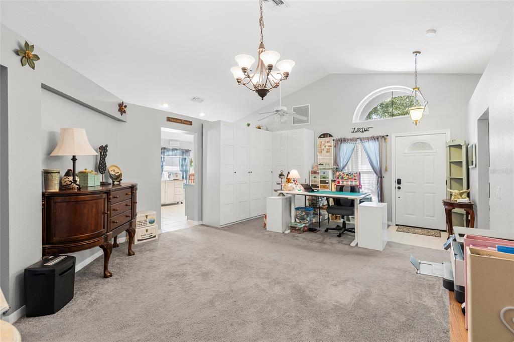 A spacious room with gray carpet, a white desk, tall storage cabinets, and a chandelier — 614 SOMERSTONE DRIVE, VALRICO, FL