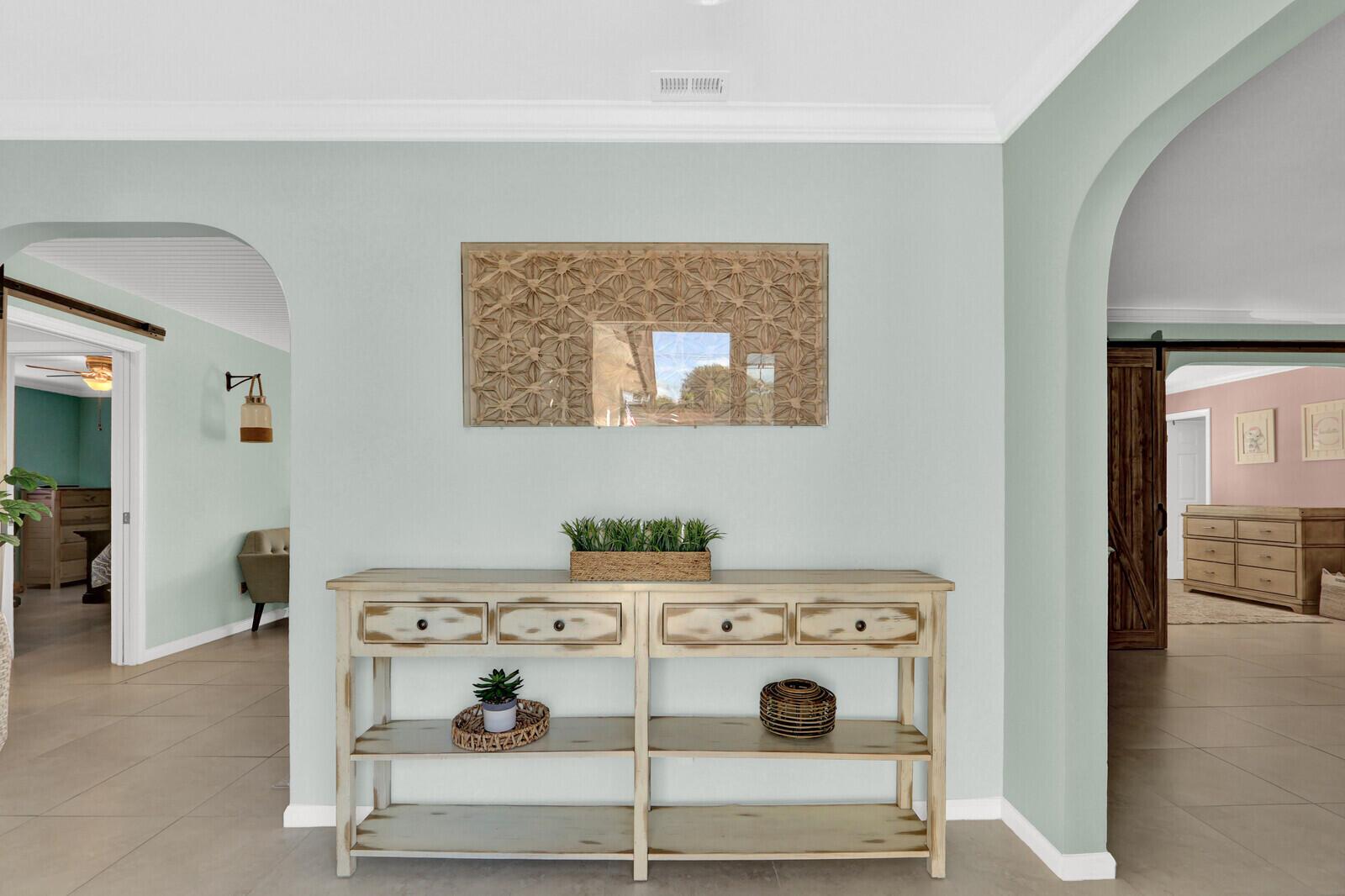 A console table sits against a light green wall beneath a decorative wooden wall mirror — 3739 Lighthouse Drive, Palm Beach Gardens FL 33410, PALM BEACH GARDENS, FL