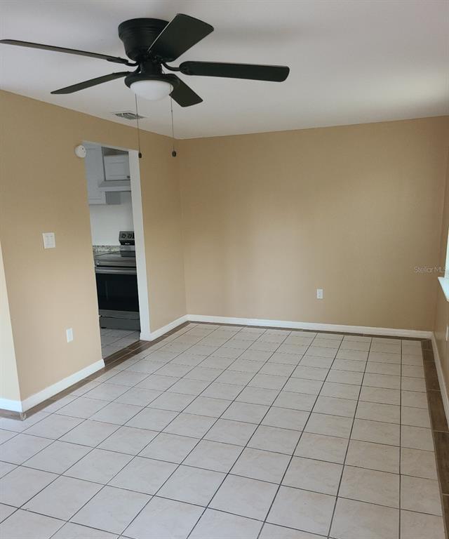 A dining area with beige walls, a ceiling fan, and light-colored square floor tiles — 4925 SANOMA VLG UNIT C, ORLANDO, FL