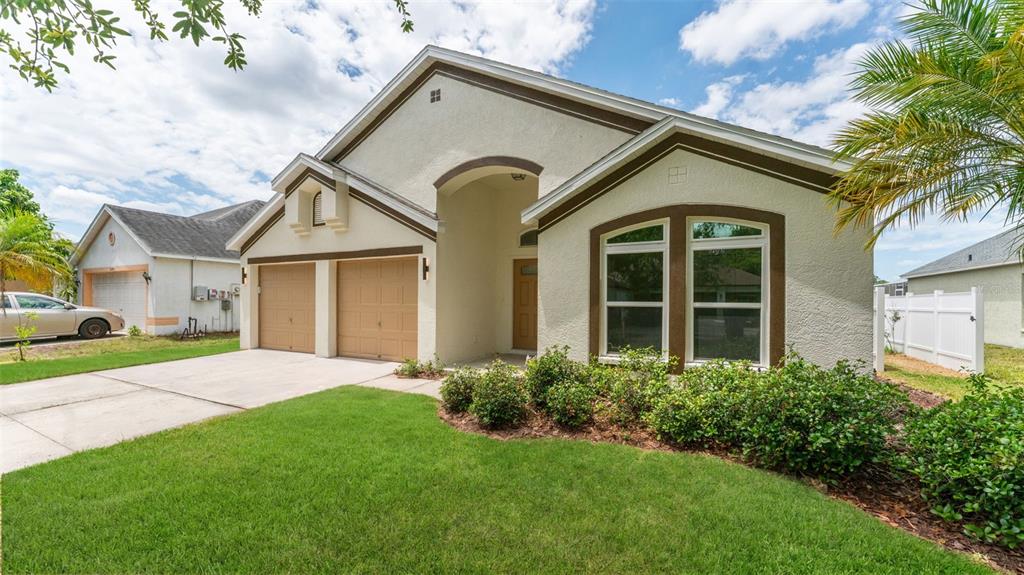 A single-story house with a two-car garage, stucco exterior, and a front lawn — 11708 CARROLLWOOD COVE DRIVE, TAMPA, FL