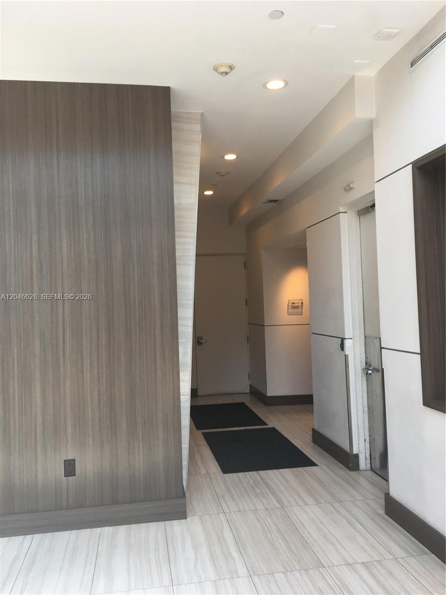 A hallway features wood-paneled walls, light-colored tile flooring, and recessed ceiling lighting — 200 Ocean Dr # 3C, Miami Beach FL 33139, MIAMI BEACH, FL