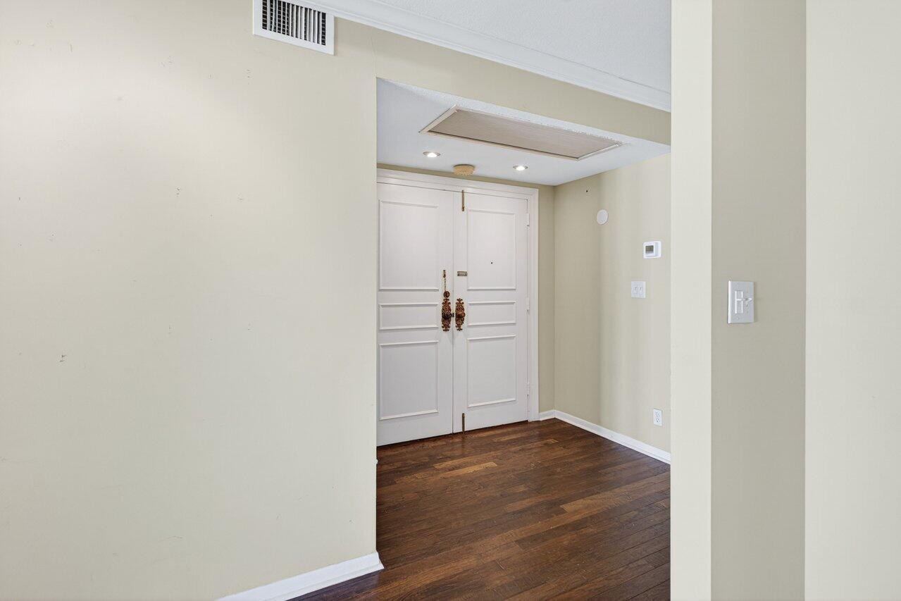 An entryway features double white doors, dark wood flooring, and light-colored walls — 2000 S Ocean Boulevard # 403, Delray Beach FL 33483, DELRAY BEACH, FL