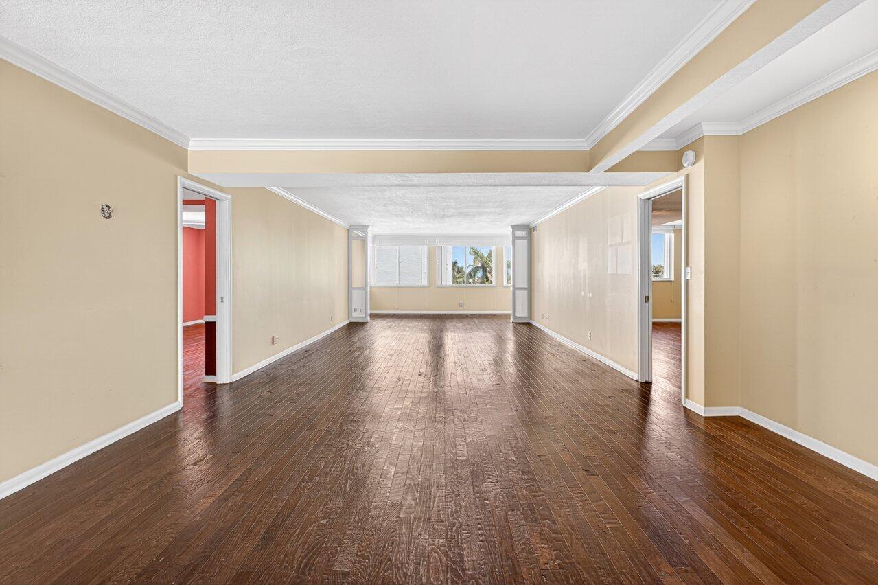 An empty room with hardwood floors, beige walls, and doorways leading to other spaces — 2000 S Ocean Boulevard # 403, Delray Beach FL 33483, DELRAY BEACH, FL
