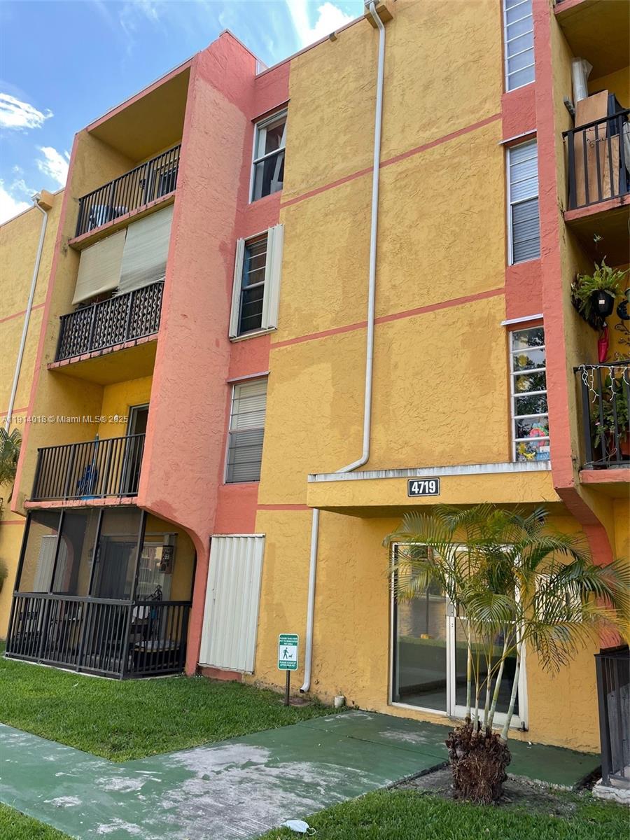 A multi-story apartment building exterior features yellow and peach stucco walls with private balconies — 4719 NW 7th St # 11, Miami FL 33126, MIAMI, FL