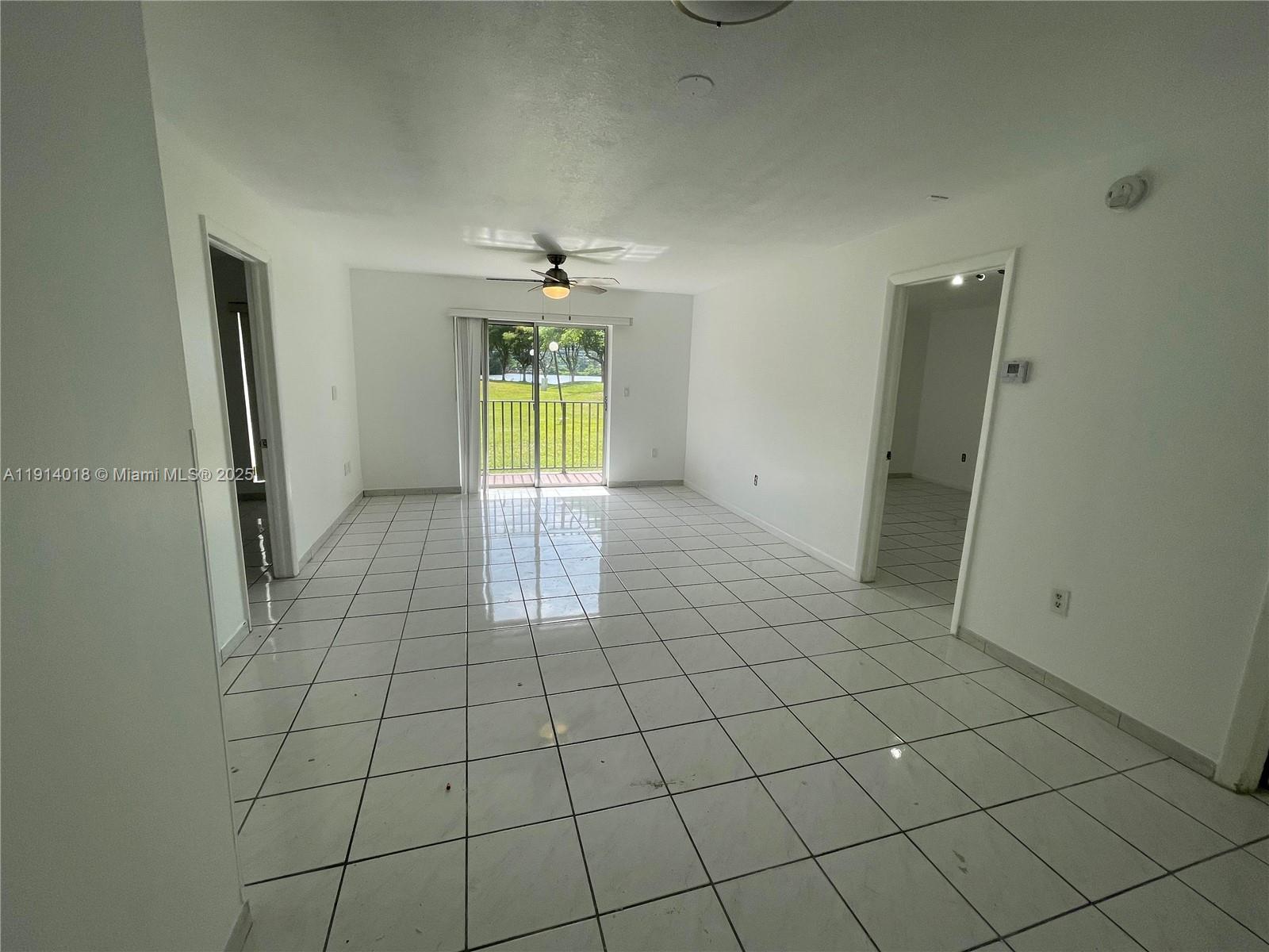 A bright living area features white tile flooring, a ceiling fan, and sliding glass doors — 4719 NW 7th St # 11, Miami FL 33126, MIAMI, FL