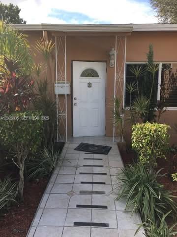 A white front door is accessed by a tiled walkway with dark rectangular inlays — 6134 SW 22nd St, Miami FL 33155, MIAMI, FL