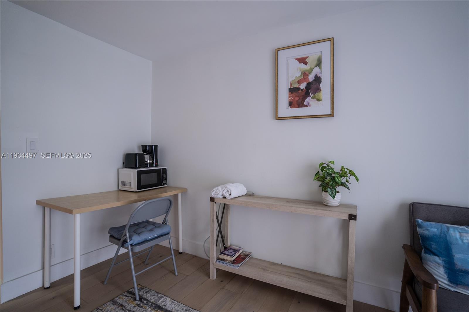 A room features a desk with a microwave, a console table, and a chair — 347 NE 110th St, Miami FL 33161, MIAMI, FL