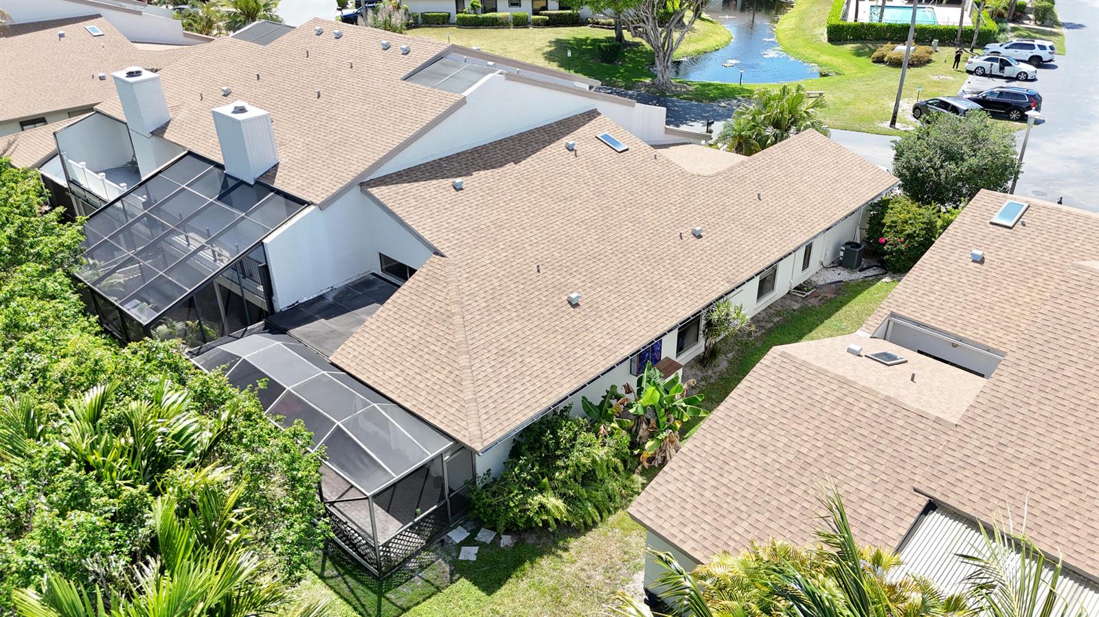 An aerial view shows the shingled roofs and screened lanais of several attached residential units — 6680 Canary Palm Circle, Boca Raton FL 33433, BOCA RATON, FL