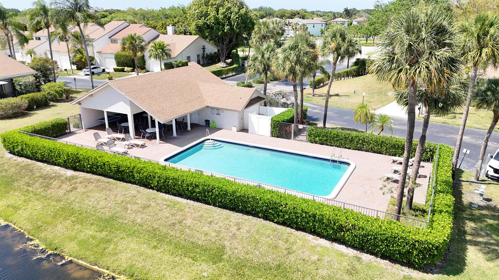 An aerial view shows a community swimming pool with a covered patio and surrounding hedges — 6680 Canary Palm Circle, Boca Raton FL 33433, BOCA RATON, FL