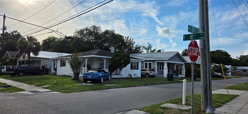 A street-level view of two single-story houses at the corner of a residential intersection — 2414 E 8TH AVENUE, TAMPA, FL
