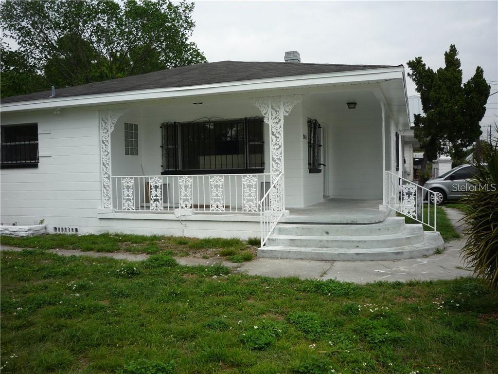 A white single-story house features a covered front porch with decorative metal railings and columns — 2414 E 8TH AVENUE, TAMPA, FL