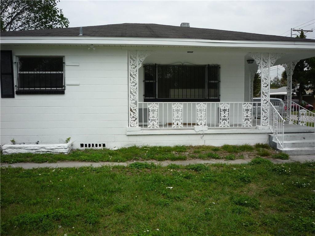 A white single-story house features a front porch with decorative metal railings and supports — 2414 E 8TH AVENUE, TAMPA, FL