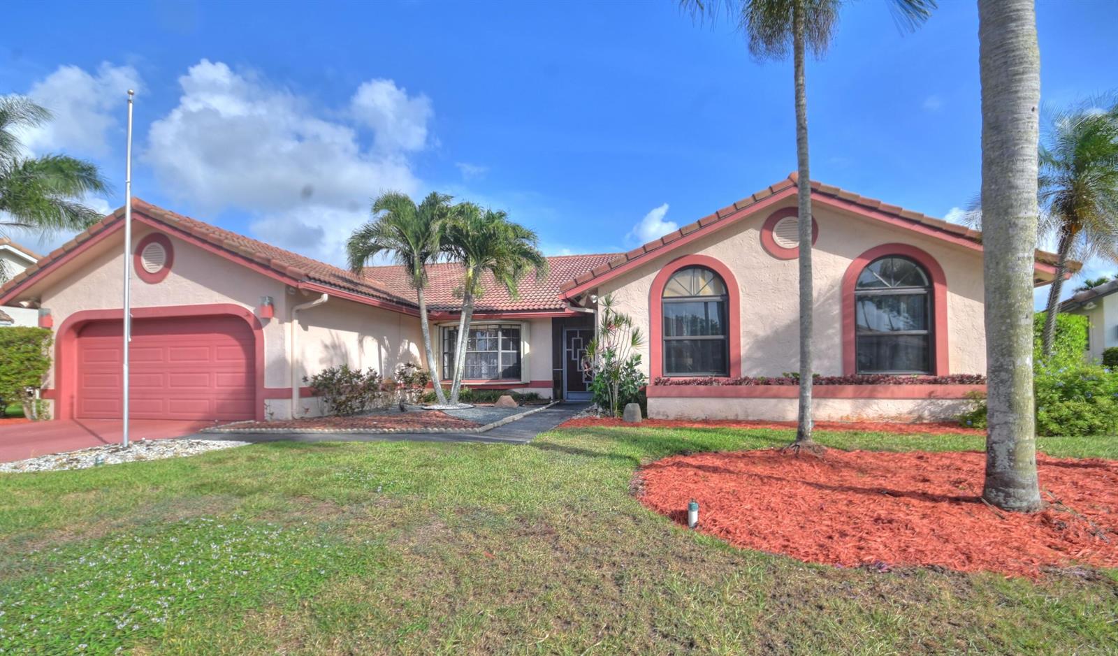 A single-story house with a red-tiled roof, pink stucco walls, and a two-car garage — 10226 Fresh Meadow Lane, Boca Raton FL 33498, BOCA RATON, FL